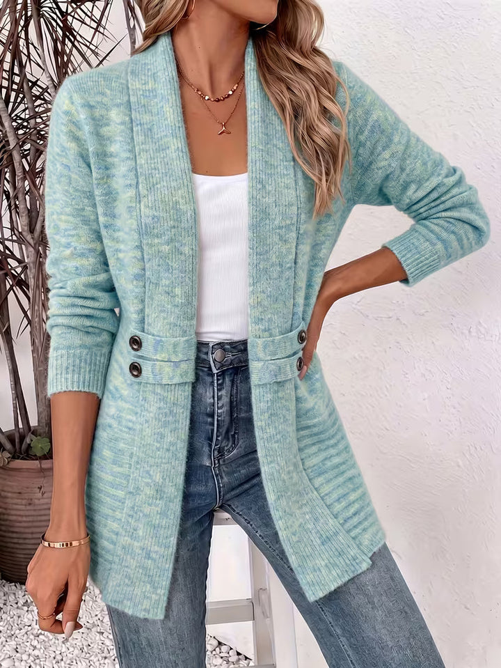 Kvinde med hånden i siden i lyseblågrøn meleret cardigan, hvid top og jeans 5