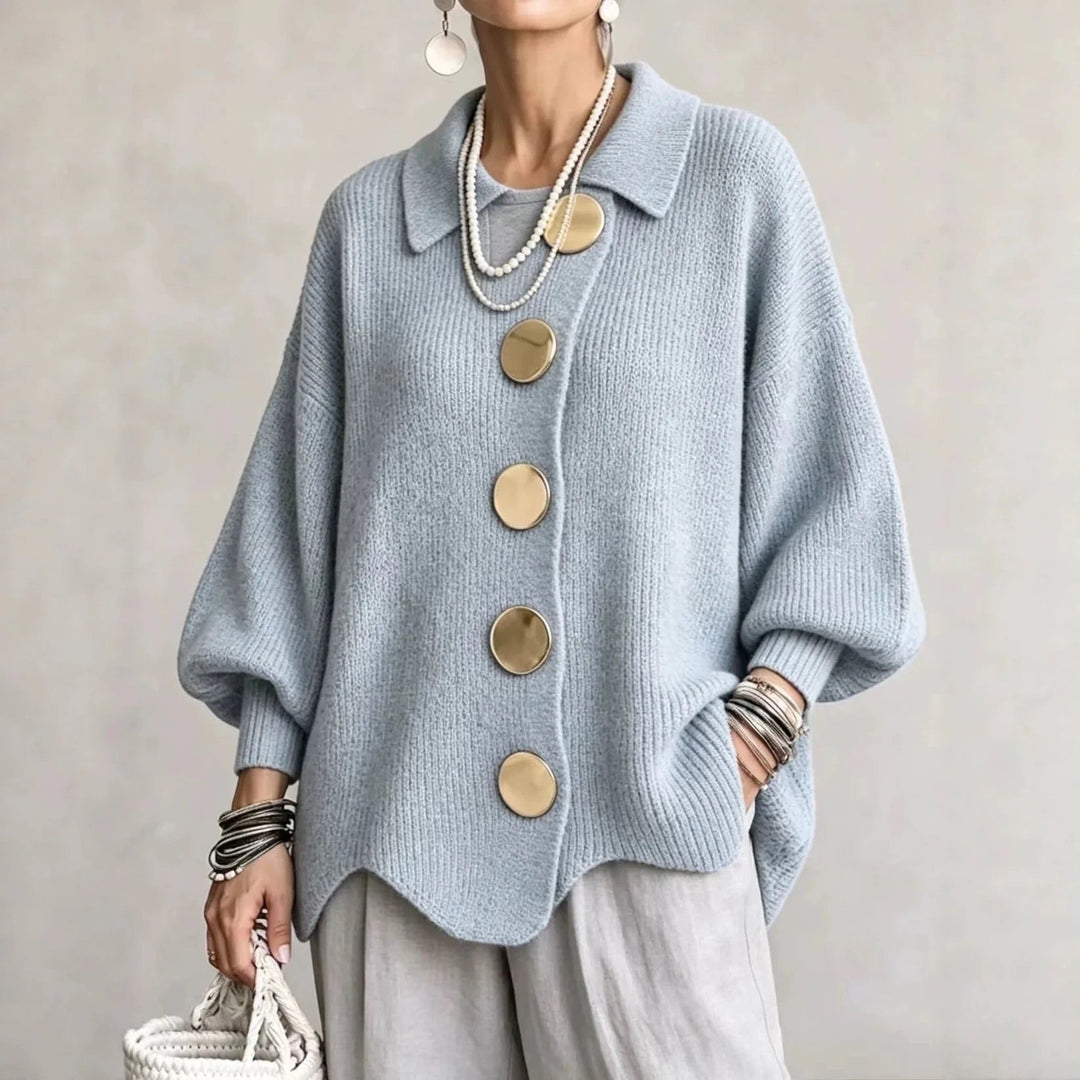 Model i lyseblå ribstrikket cardigan med store guldfarvede knapper, bølgekant og balloner ærmer, set forfra. 5