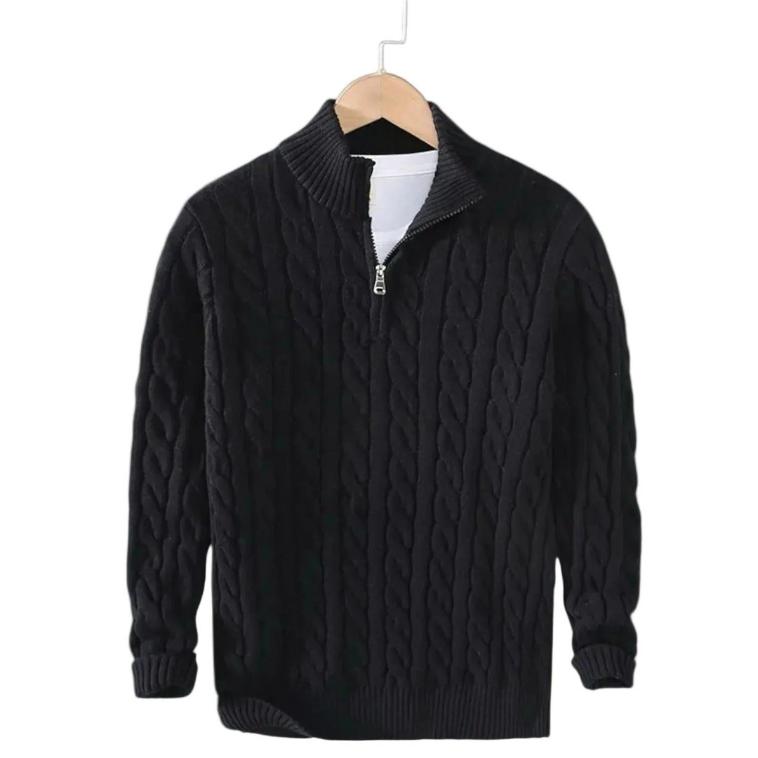 Sort kabelstrikket trøje med halv rullekrave og kort lynlås, hængende på en bøjle med hvid t-shirt under. 2