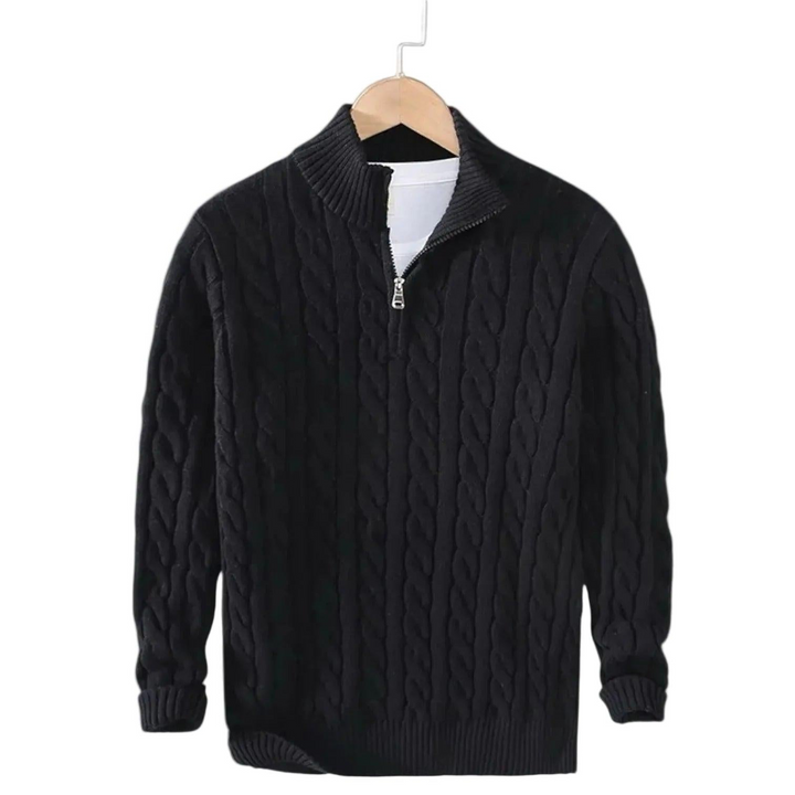 Sort kabelstrikket trøje med halv rullekrave og kort lynlås, hængende på en bøjle med hvid t-shirt under. 2