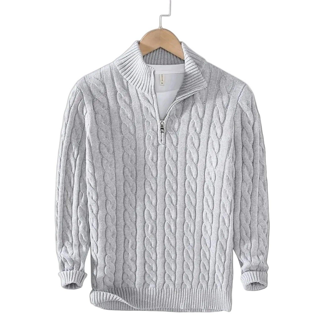Lysegrå kabelstrikket trøje med halv rullekrave og kort metallynlås, hængende på en bøjle med hvid t-shirt under. 4