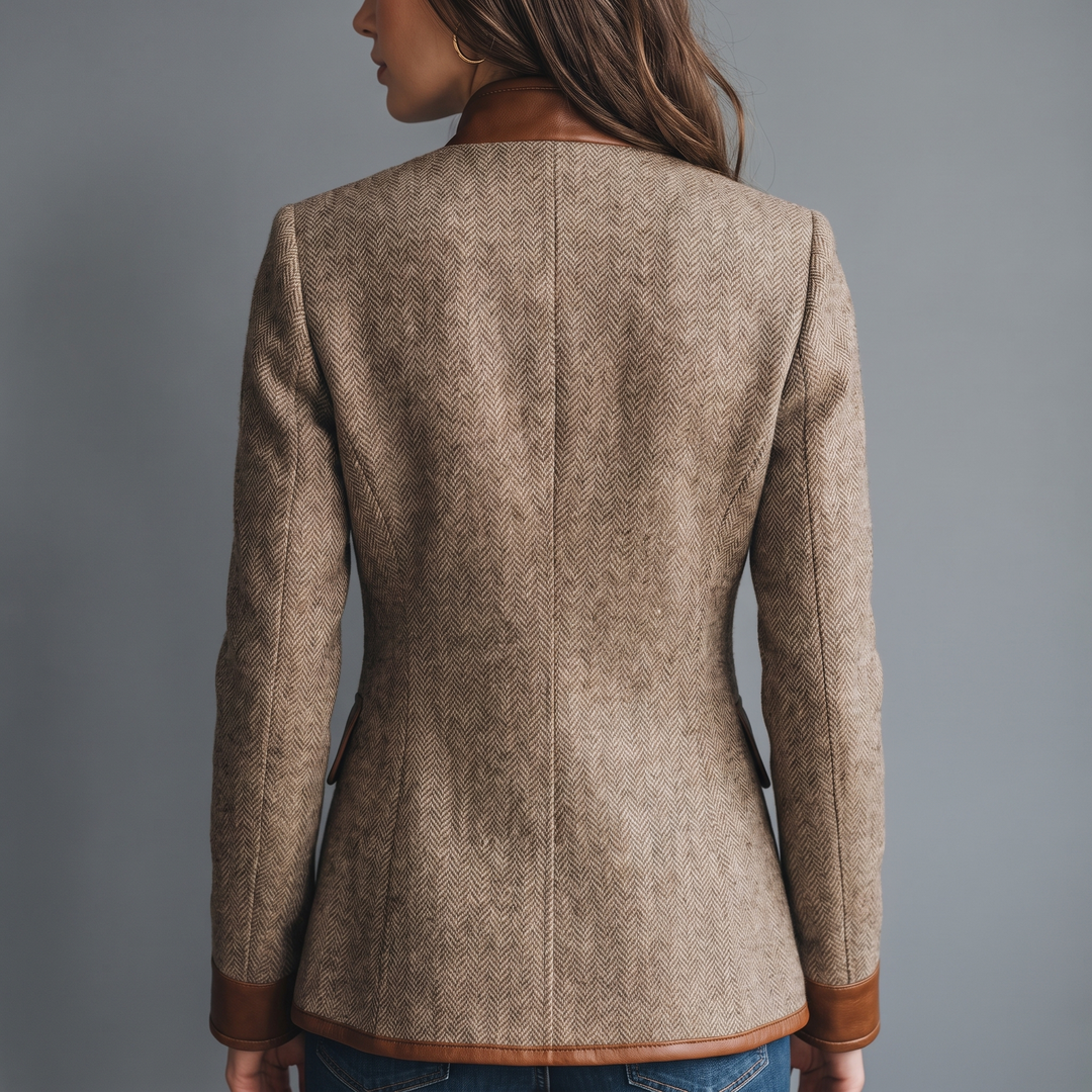 Jakken set bagfra på model, med sildebensvævet tweed, kunstlæderkrave, kunstlædermanchetter og kunstlæderkant forneden. 3