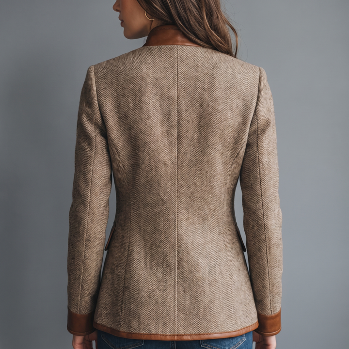 Jakken set bagfra på model, med sildebensvævet tweed, kunstlæderkrave, kunstlædermanchetter og kunstlæderkant forneden. 3