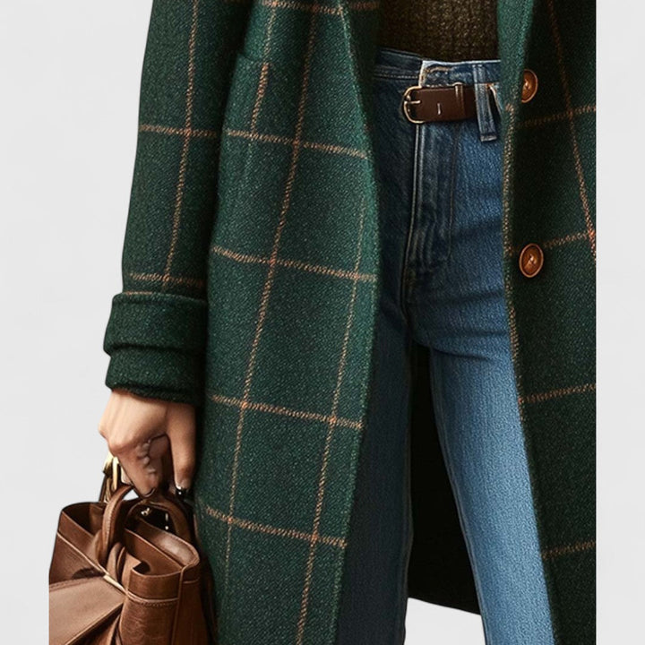 Detaljebillede af frakkens nederste del med lommer, oprullet ærmeopslag og to knapper, båret med jeans og brun taske. 4