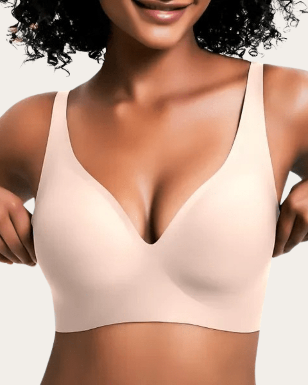 Model viser bh'en forfra i ensfarvet lys beige med glat overflade og dyb V-udskæring. 6
