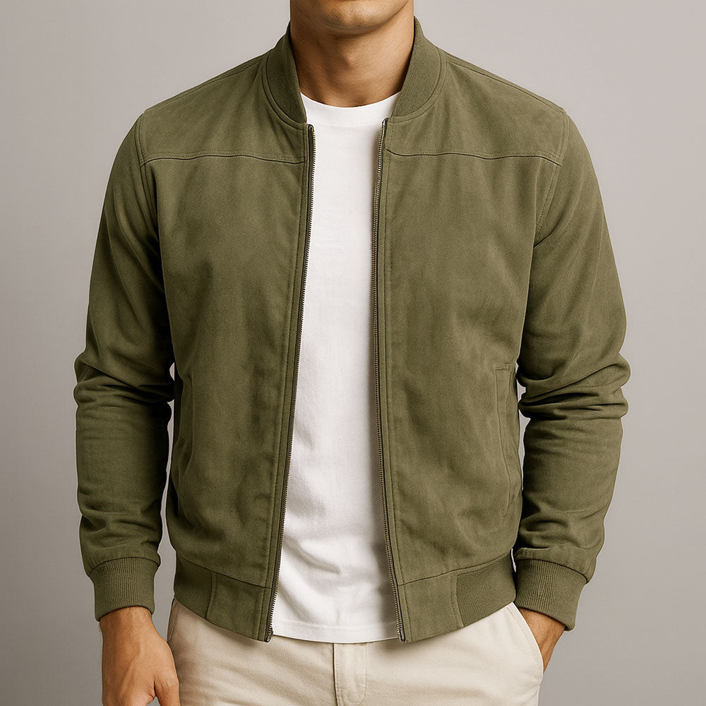 Model i olivengrøn jakke med åben lynlås, ribkant og sømme over skuldrene, båret med hvid t-shirt. 3