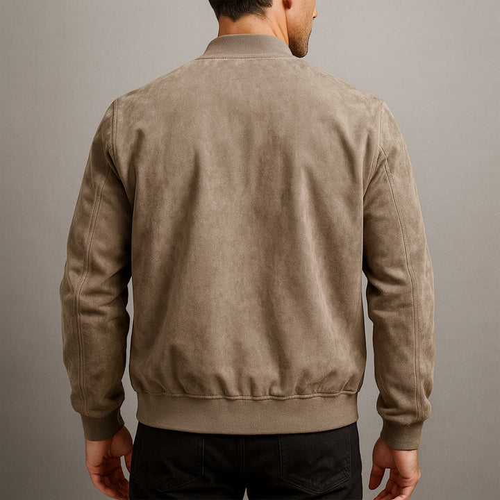 Model set bagfra i beige jakke med ribkrave og ribkant forneden, glat ryg og sorte bukser. 7