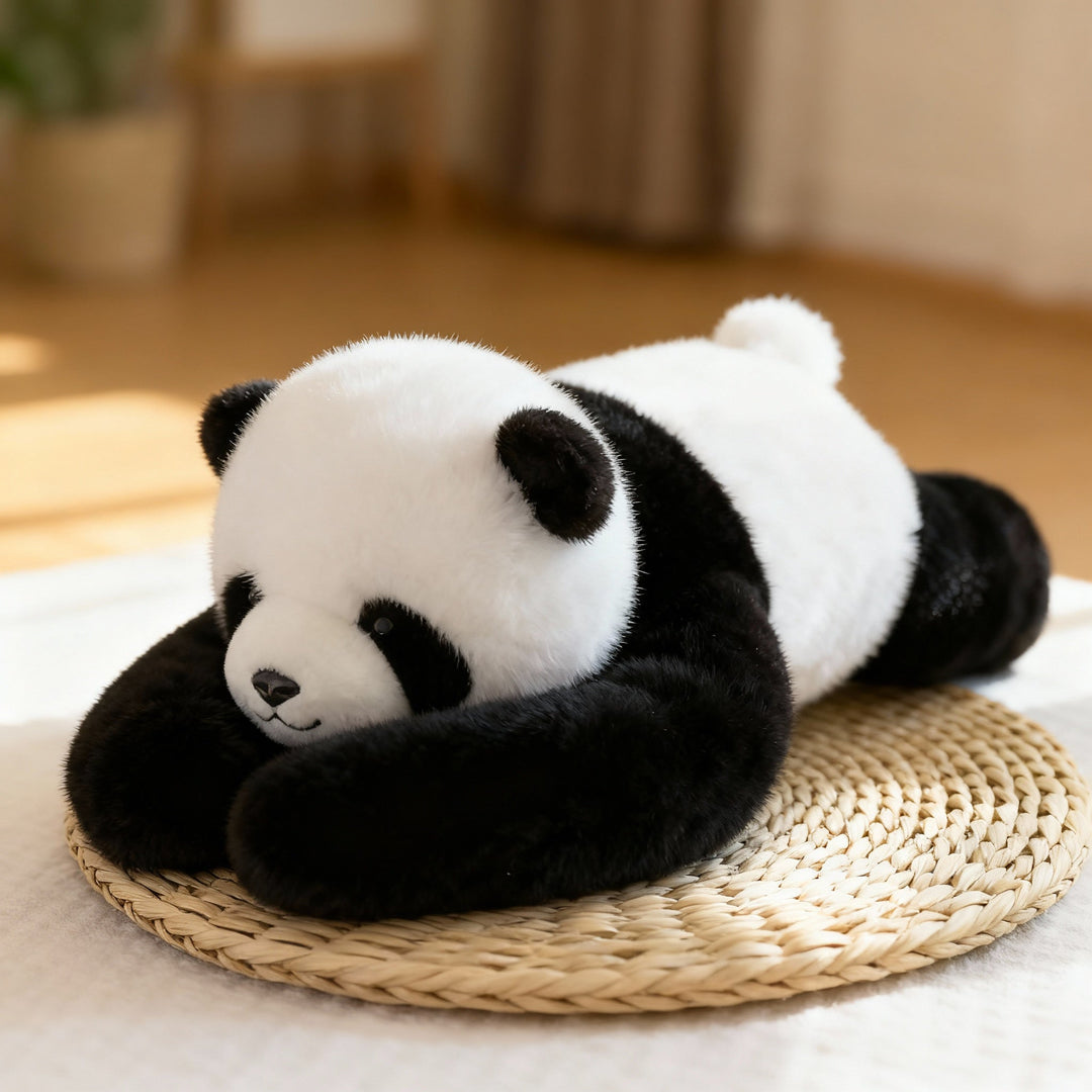 Sort-hvid panda-krammedyr med lange arme ligger afslappet på en rund flettet underlag i lyst stueindhold. 1