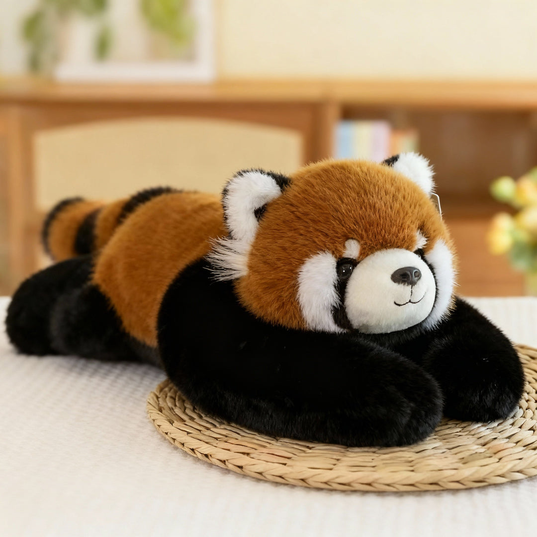 Rød panda-krammedyr med rustbrun pels, sorte ben og lange sorte arme ligger på et flettet underlag. 13