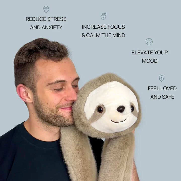 Smilende mand holder dovendyr-krammedyret med de lange arme om nakken og kinden presset mod dets hoved. 7