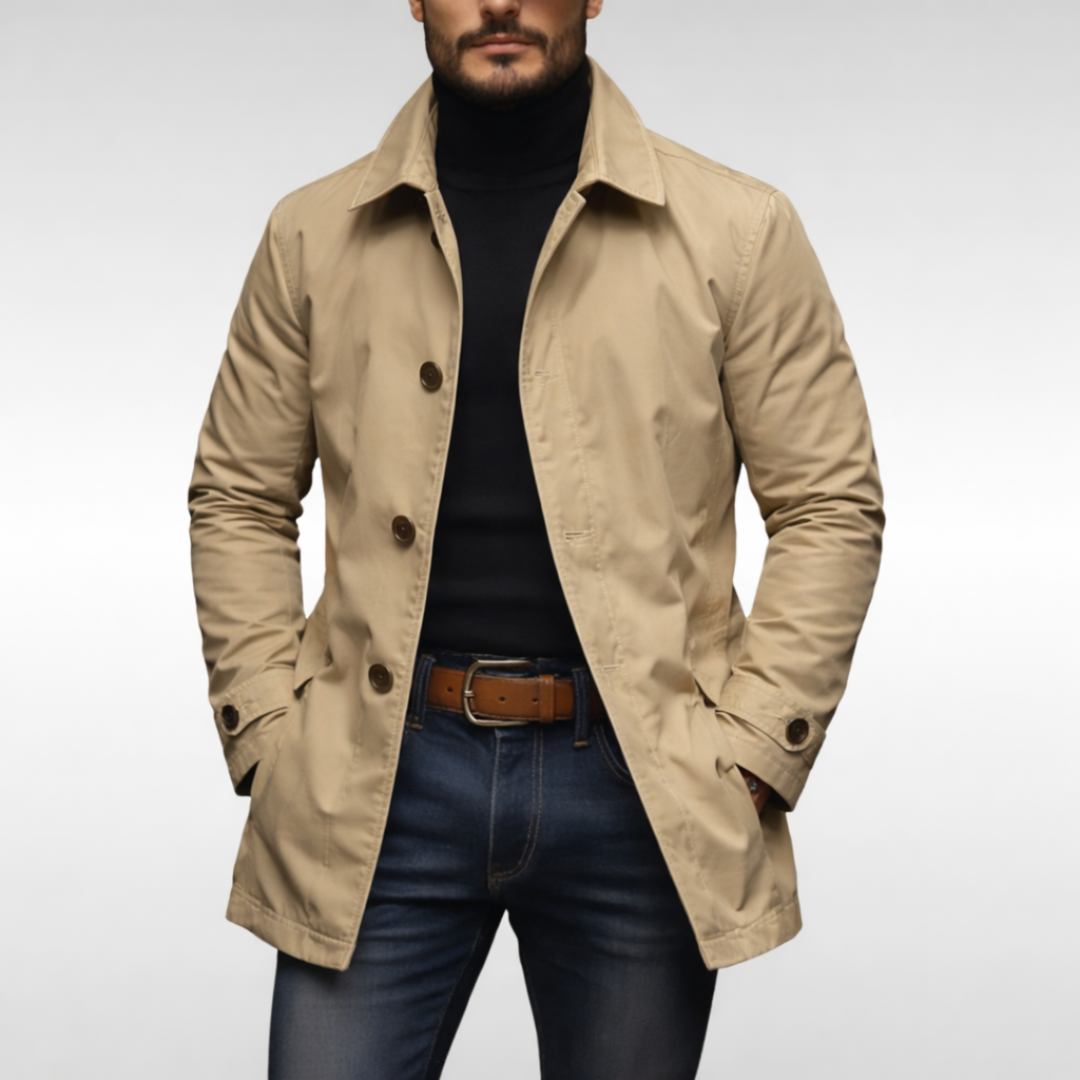 Beige udgave af frakken på model med sort rullekravetrøje, jeans og brunt læderbælte, set forfra. 5