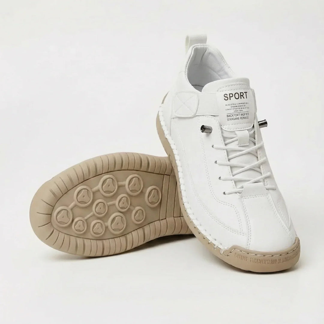 Hvid sko med elastiske snørebånd og beige gummisål, den anden sko vender sålen opad med cirkelmønster. 2
