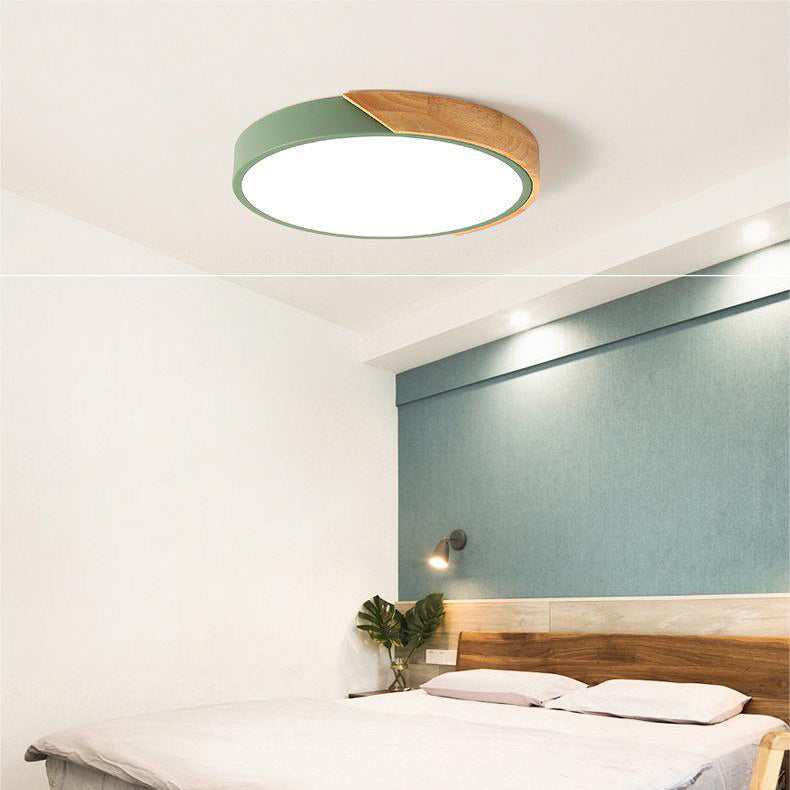 Grøn rund loftslampe med trædetalje i loftet over et soveværelse med seng og blågrøn væg. 6