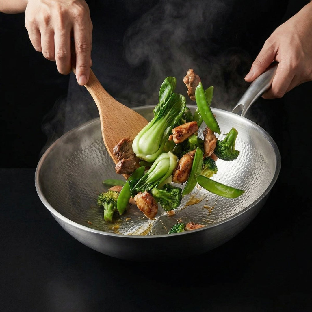 Hænder rører med en træspatel rundt i woken med kylling, pak choi, broccoli og sukkerærter under tilberedning. 7