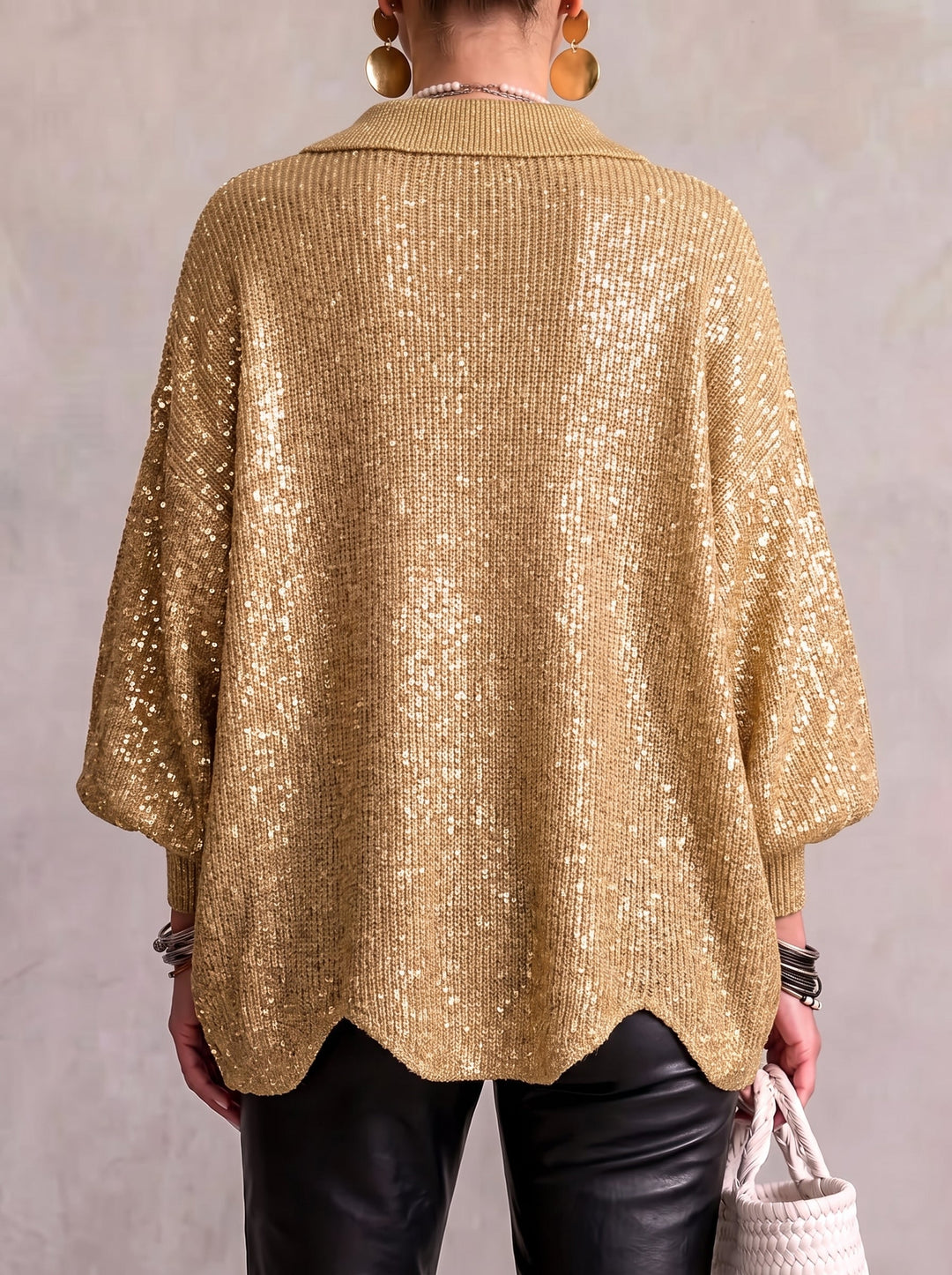 Model set bagfra i guldfarvet paillet-cardigan med bølgekant og brede ærmer, båret med sorte læderbukser. 14