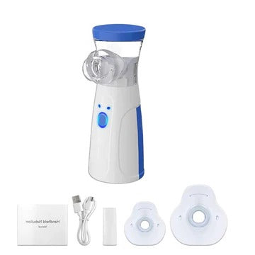 Nebulisatoren stillet frem sammen med USB-kabel, munstykke, to masker og en foldet brugsanvisning på hvid baggrund. 9