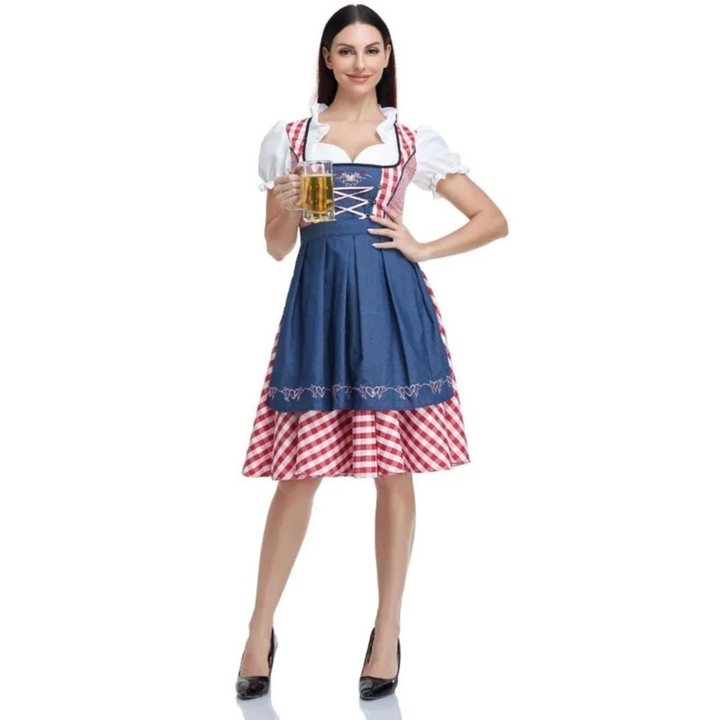 Model i dirndl med blåt forklæde over rød-hvidt ternet skørt, helfigur forfra med et glas øl i hånden. 7