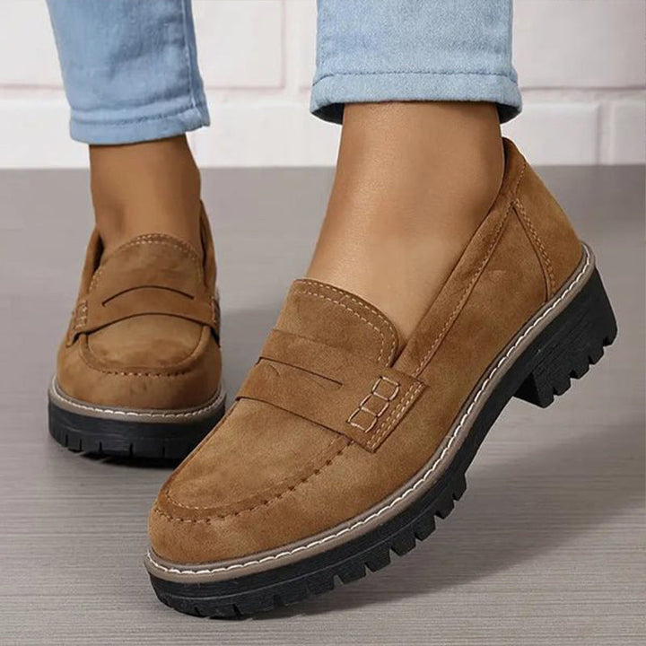 Brune ruskindslignende loafers med synlig syning og kraftig sort sål, båret med lyseblå jeans. 5