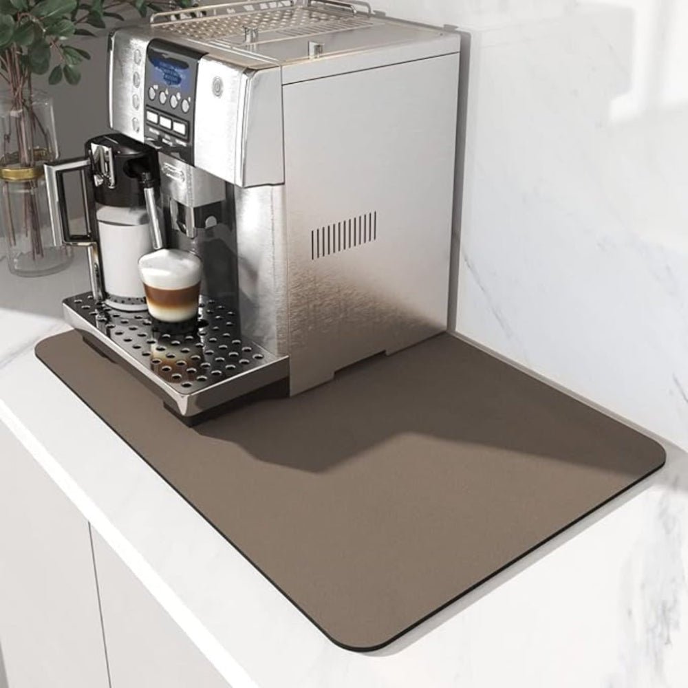 Brun måtte med afrundede hjørner under en fuldautomatisk kaffemaskine på en lys bordplade ved en marmorvæg. 3