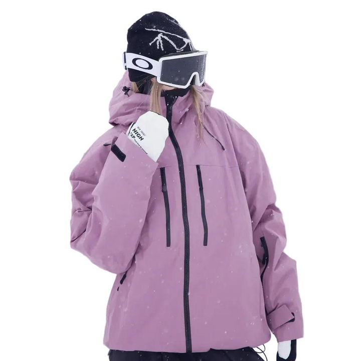 Model i lyselilla snejakke med hætte, skibriller og hvide handsker, hvor den ene hånd er løftet mod hagen. 2